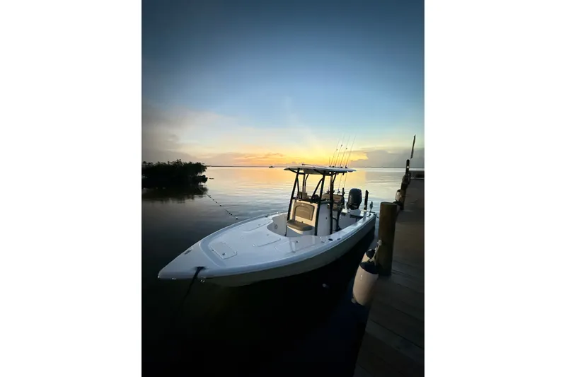 Slide: The Image of 2025 Sea Hunt BX22BR boat docked at sunset, calm waters, and serene sky. - 8