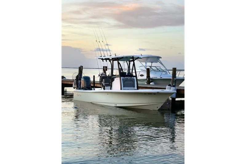 Slide: The Image of 2025 Sea Hunt BX22BR boat docked at sunset, calm waters reflecting the sky. - 2
