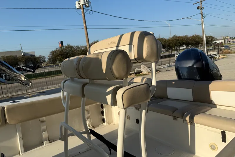 Slide: The Image of 2016 NauticStar 2302 Legacy boat interior with beige seating and outboard motor. - 14