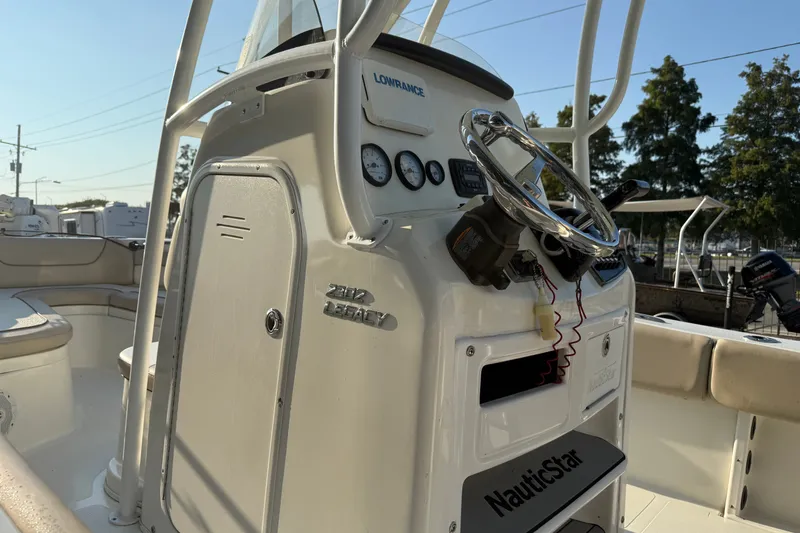 Slide: The Image of 2016 NauticStar 2302 Legacy boat console with steering wheel and gauges. - 15
