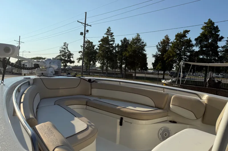 Slide: The Image of 2016 NauticStar 2302 Legacy boat interior with cushioned seating and clear sky background. - 17