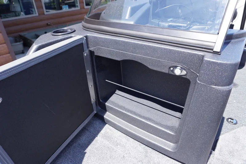 Slide: The Image of 2027 Tracker Targa V-18 Combo boat storage compartment with open door and windshield. - 17