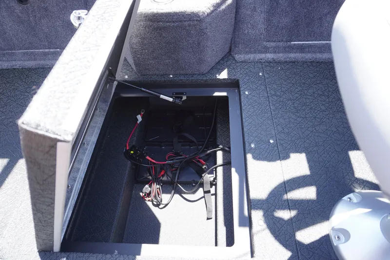 Slide: The Image of Open storage compartment in 2027 Tracker Targa V-18 Combo boat, showing wiring and battery setup. - 19