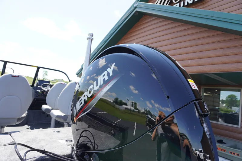 Slide: The Image of 2027 Tracker Targa V-18 Combo boat with Mercury engine, parked near a wooden building. - 22