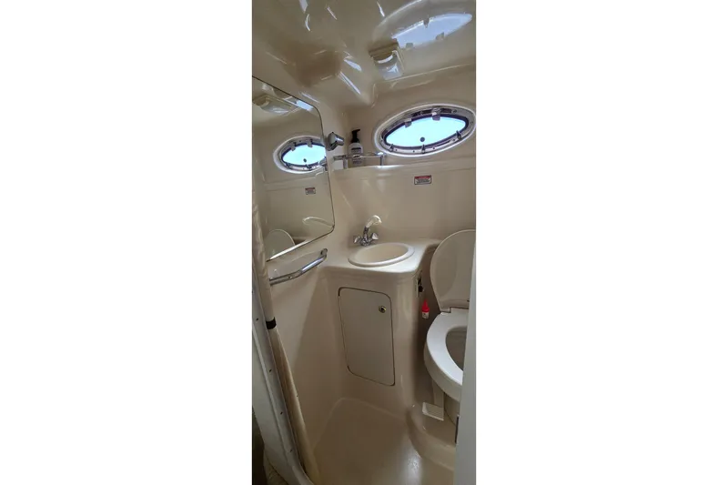 Slide: The Image of 2003 Sea Ray Sundancer 260 bathroom with sink, toilet, and porthole window. - 25
