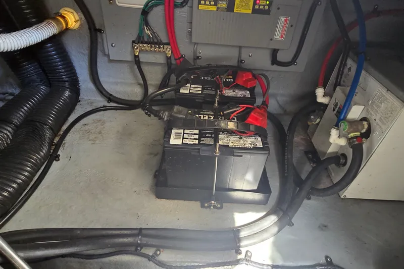 Slide: The Image of Battery compartment of a 2003 Sea Ray Sundancer 260 boat, showing dual batteries and wiring. - 28