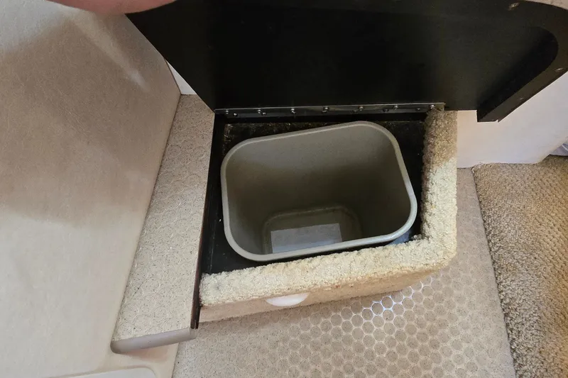 Slide: The Image of Storage compartment with trash bin in 2003 Sea Ray Sundancer 260 boat interior. - 23