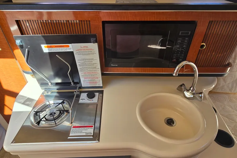 Slide: The Image of 2003 Sea Ray Sundancer 260 galley with stove, microwave, and sink. - 20