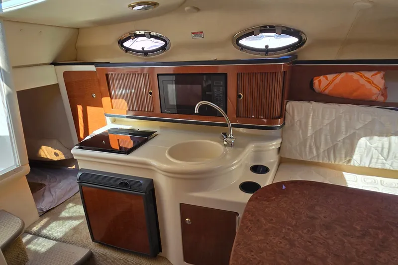 Slide: The Image of Interior of 2003 Sea Ray Sundancer 260 boat with kitchenette and portholes. - 18