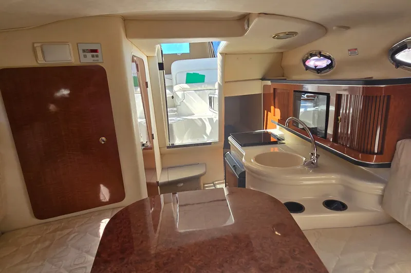 Slide: The Image of Interior of 2003 Sea Ray Sundancer 260, featuring kitchenette and seating area. - 19
