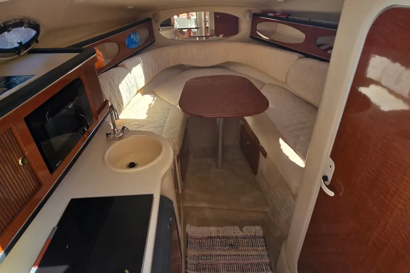 Slide: The Image of Interior of 2003 Sea Ray Sundancer 260 boat with kitchenette and seating area. - 16