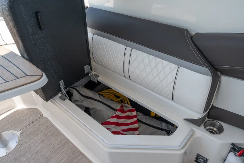 Slide: The Image of 2017 Sea Ray SLX 350 boat storage compartment with open lid, revealing interior items. - 35