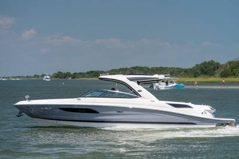 Slide: The Image of 2017 Sea Ray SLX 350 cruising on a serene lake under a clear blue sky. - 4
