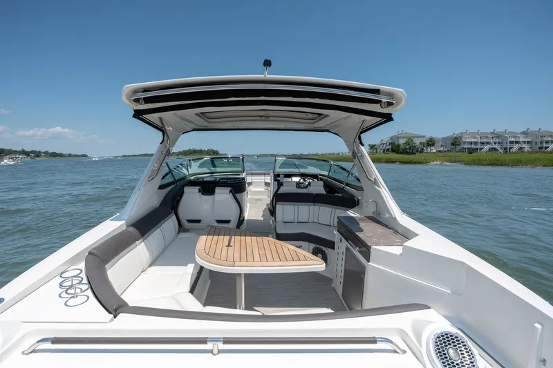 Slide: The Image of 2017 Sea Ray SLX 350 boat interior with seating and table on a sunny day. - 38