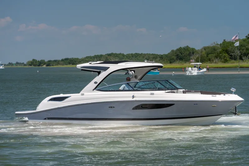 Slide: The Image of 2017 Sea Ray SLX 350 boat cruising on a serene lake with lush greenery. - 9