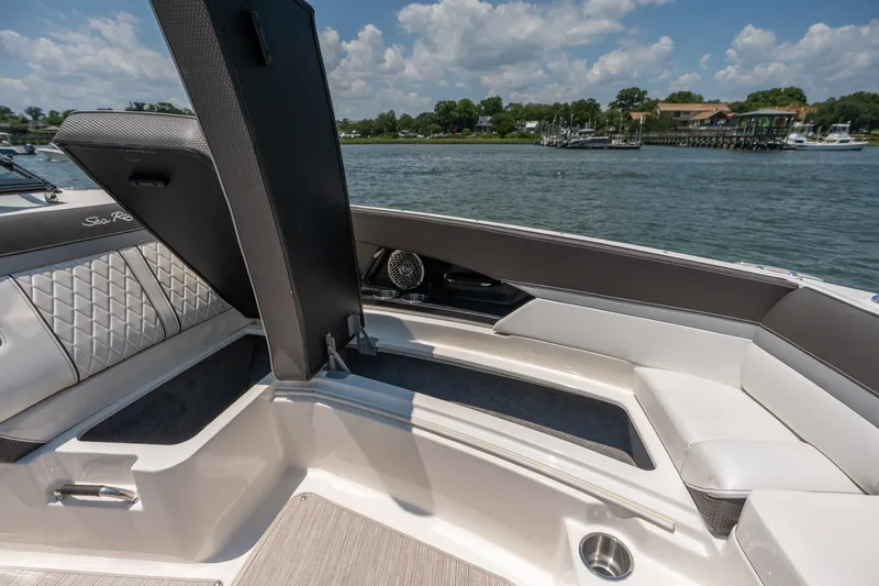 Slide: The Image of 2017 Sea Ray SLX 350 boat interior with open storage compartment, docked by a scenic waterfront. - 14