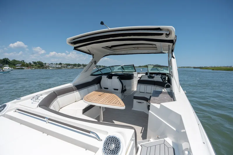 Slide: The Image of 2017 Sea Ray SLX 350 boat interior with seating and table on a sunny day. - 39