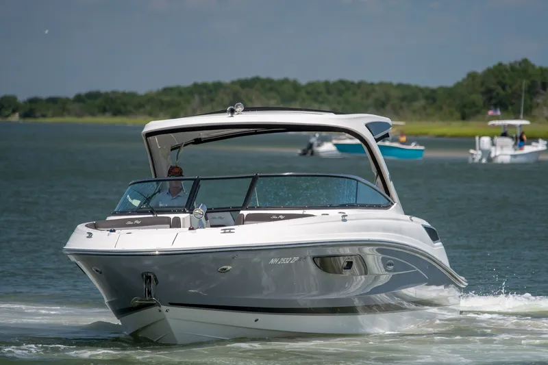 Slide: The Image of 2017 Sea Ray SLX 350 boat cruising on a calm lake with scenic background. - 6