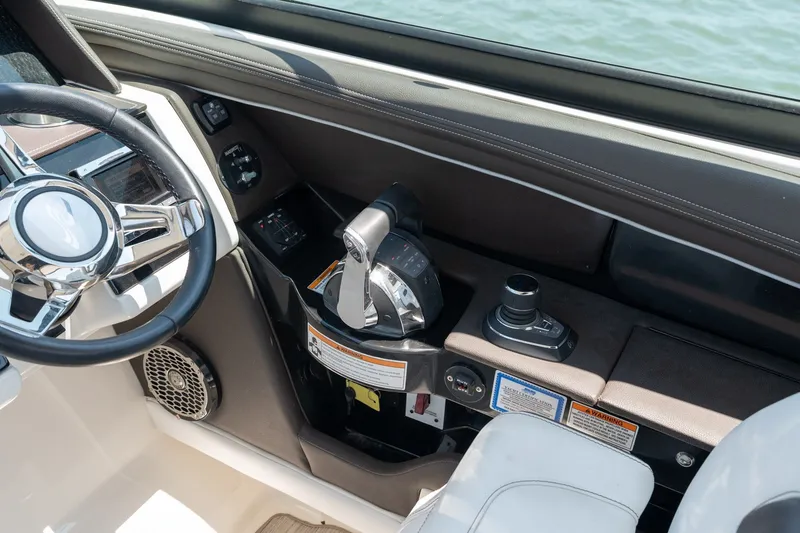 Slide: The Image of 2017 Sea Ray SLX 350 helm with steering wheel and control panel, overlooking water. - 22