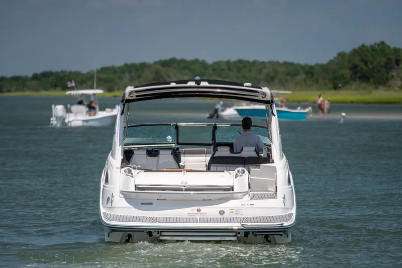 Slide: The Image of 2017 Sea Ray SLX 350 boat cruising on a calm lake with scenic background. - 2