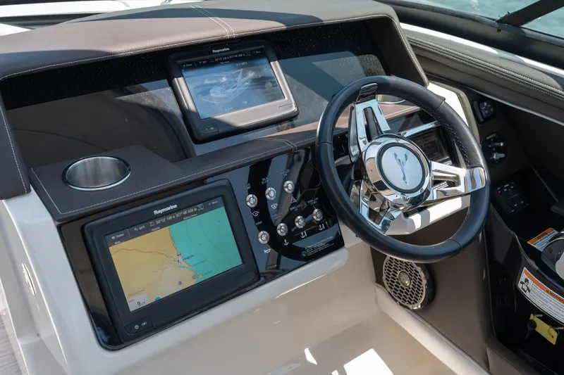 Slide: The Image of 2017 Sea Ray SLX 350 helm with navigation screens and steering wheel. - 21