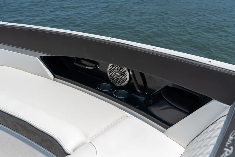 Slide: The Image of 2017 Sea Ray SLX 350 boat interior with seating, cup holders, and speaker by the water. - 13
