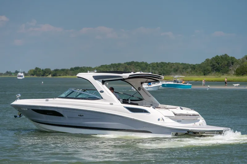 Slide: The Image of 2017 Sea Ray SLX 350 cruising on a sunny day near a lush shoreline. - 3
