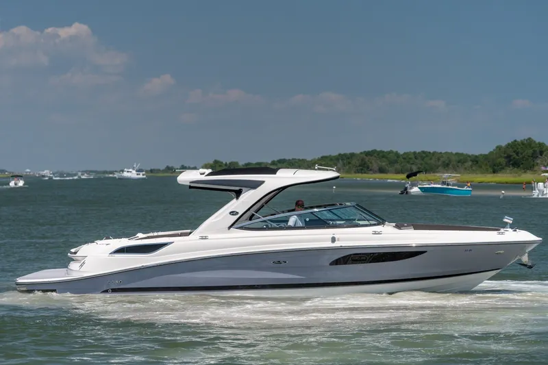 Slide: The Image of 2017 Sea Ray SLX 350 cruising on a sunny day, surrounded by calm waters and distant boats. - 10