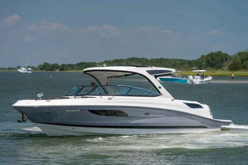 Slide: The Image of 2017 Sea Ray SLX 350 boat cruising on a calm lake under a clear blue sky. - 5