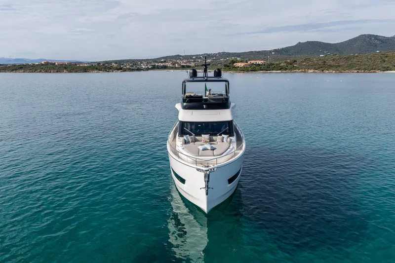 Slide: The Image of 2026 Cranchi Sessantadue 62 yacht on serene blue waters, coastal landscape in background. - 6