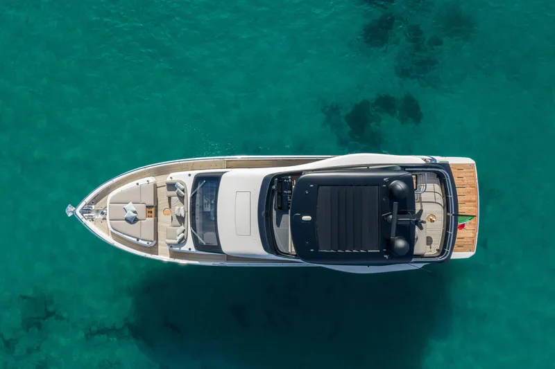 Slide: The Image of Aerial view of 2026 Cranchi Sessantadue 62 yacht on clear turquoise water. - 2
