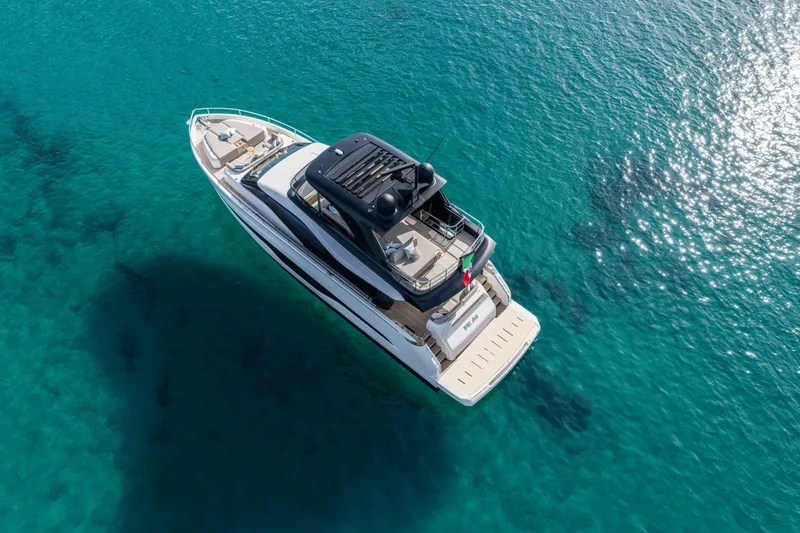 Slide: The Image of Aerial view of 2026 Cranchi Sessantadue 62 yacht on clear turquoise water. - 3