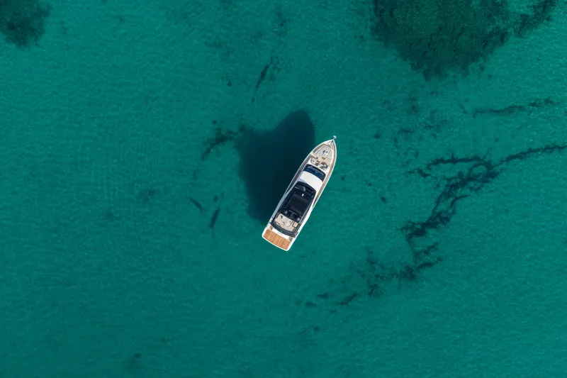Slide: The Image of Aerial view of 2026 Cranchi Sessantadue 62 yacht on clear turquoise water. - 18