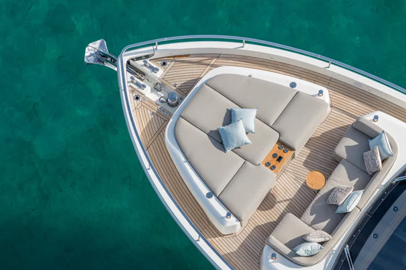 Slide: The Image of Luxurious 2026 Cranchi Sessantadue 62 yacht deck with plush seating and cushions on turquoise water. - 20