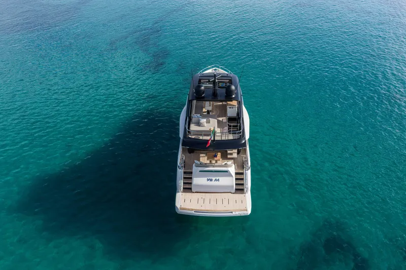 Slide: The Image of 2026 Cranchi Sessantadue 62 yacht on clear turquoise water, aerial view. - 4