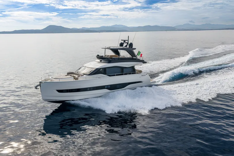 Slide: The Image of 2026 Cranchi Sessantadue 62 yacht cruising on open water, scenic mountain backdrop. - 26