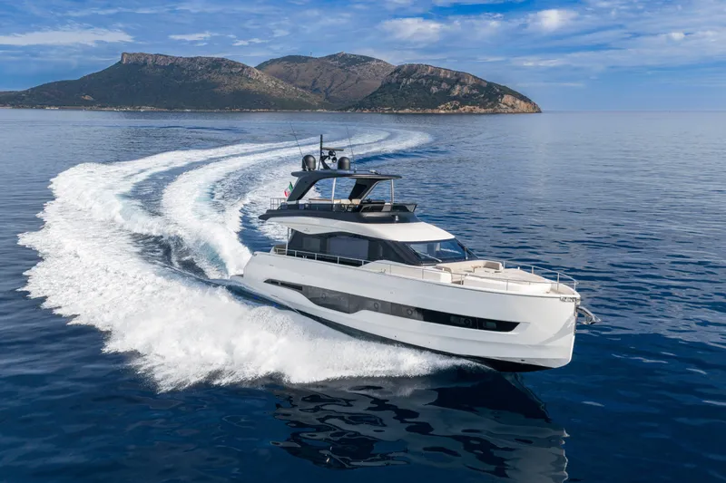 Slide: The Image of Luxurious 2026 Cranchi Sessantadue 62 yacht cruising on open sea with scenic mountain backdrop. - 29