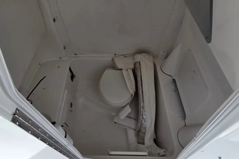Slide: The Image of Interior of 2015 Tidewater 280 CC Adventure boat showing compact bathroom space. - 16