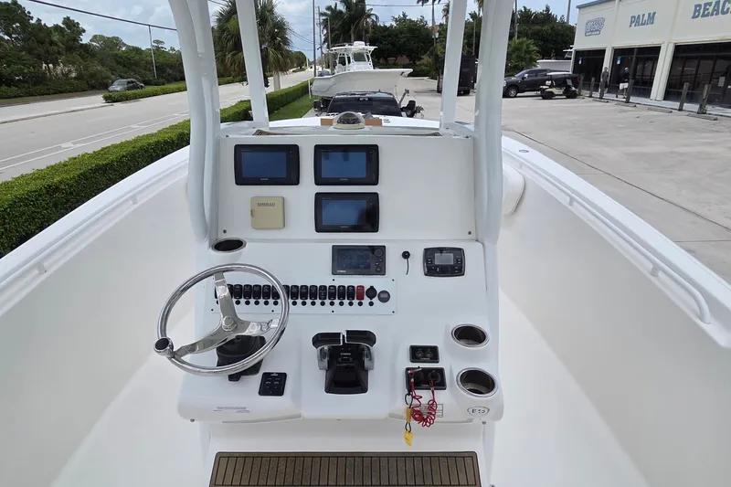Slide: The Image of 2015 Tidewater 280 CC Adventure boat dashboard with steering wheel and navigation controls. - 8