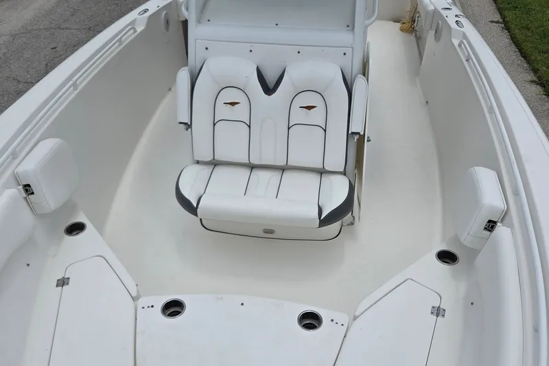 Slide: The Image of 2015 Tidewater 280 CC Adventure boat interior with white seating and cup holders. - 12