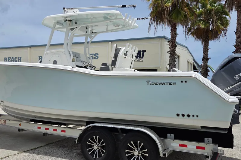 Slide: The Image of 2015 Tidewater 280 CC Adventure boat on trailer, parked near palm trees. - 1