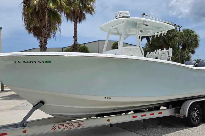 Slide: The Image of 2015 Tidewater 280 CC Adventure boat on trailer, palm trees in background. - 2