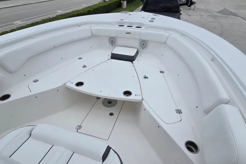 Slide: The Image of 2015 Tidewater 280 CC Adventure boat interior with white seating and storage compartments. - 10
