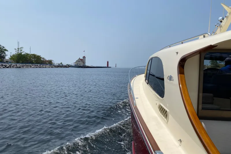 Slide: The Image of 2018 Palm Beach Motor Yachts PB50 cruising near a lighthouse on a sunny day. - 31