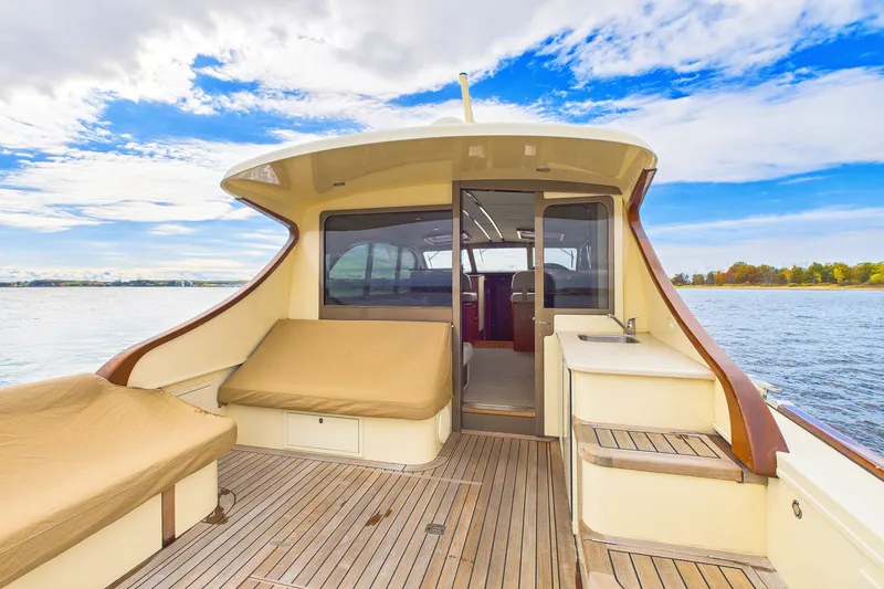 Slide: The Image of 2018 Palm Beach Motor Yachts PB50 with spacious deck, elegant seating, and scenic water view. - 13