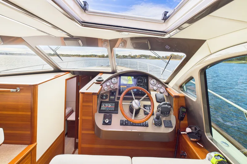 Slide: The Image of 2018 Palm Beach Motor Yachts PB50 helm with wooden accents and modern navigation equipment. - 3