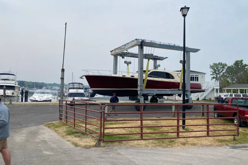 Slide: The Image of 2018 Palm Beach Motor Yachts PB50 on lift at marina, surrounded by other boats. - 30
