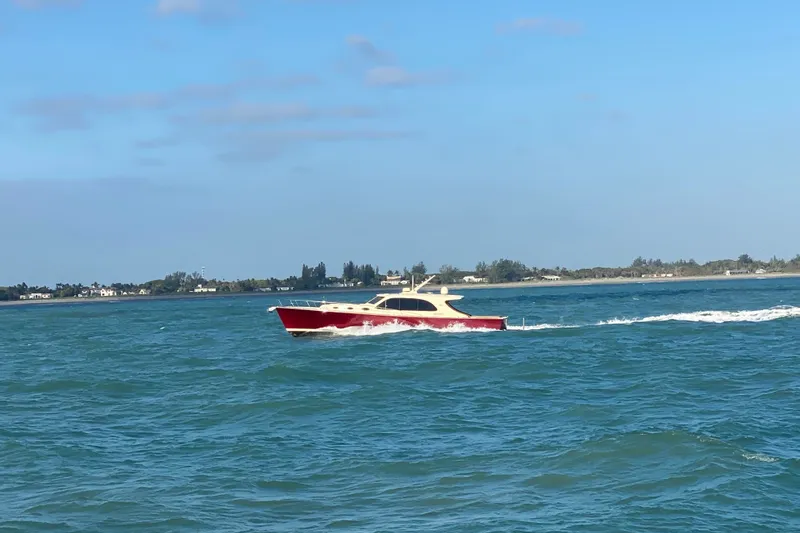 Slide: The Image of 2018 Palm Beach Motor Yachts PB50 cruising on open water under clear blue skies. - 2