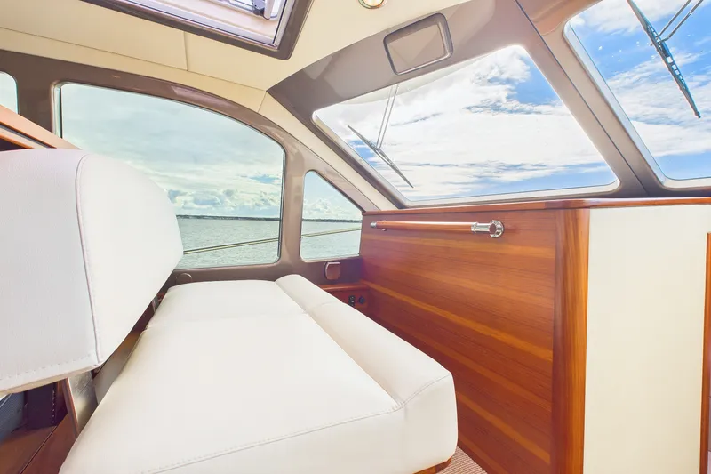 Slide: The Image of Interior view of 2018 Palm Beach Motor Yachts PB50, featuring elegant wood paneling and ocean view. - 5