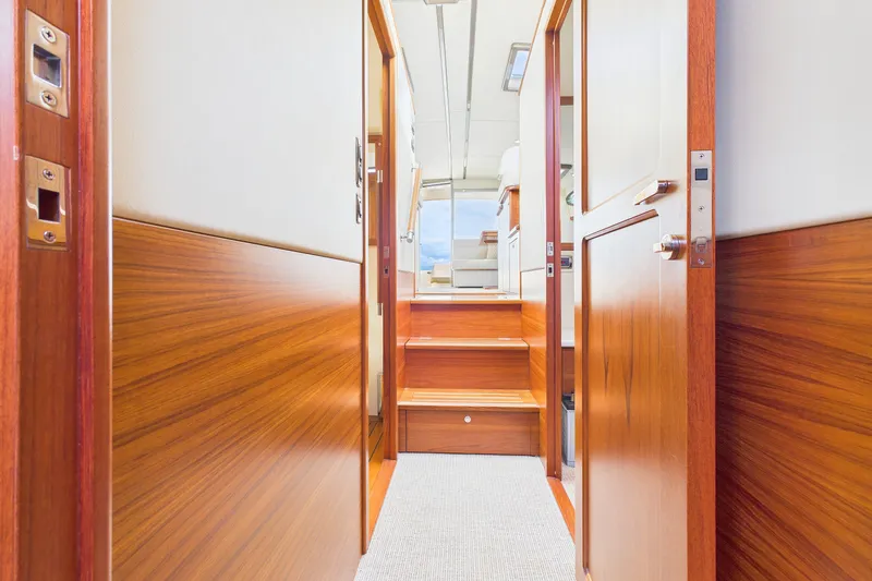 Slide: The Image of Interior view of 2018 Palm Beach Motor Yachts PB50, featuring elegant wood paneling and stairs. - 16